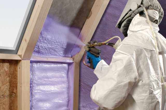 a technician spraying insulation
