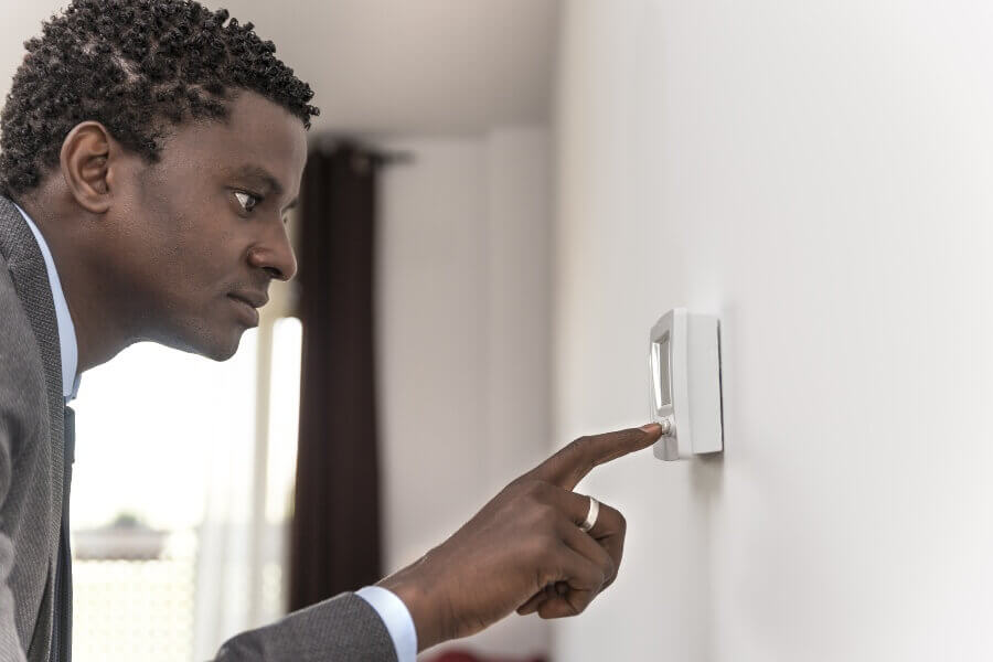 a person adjusting a thermostat